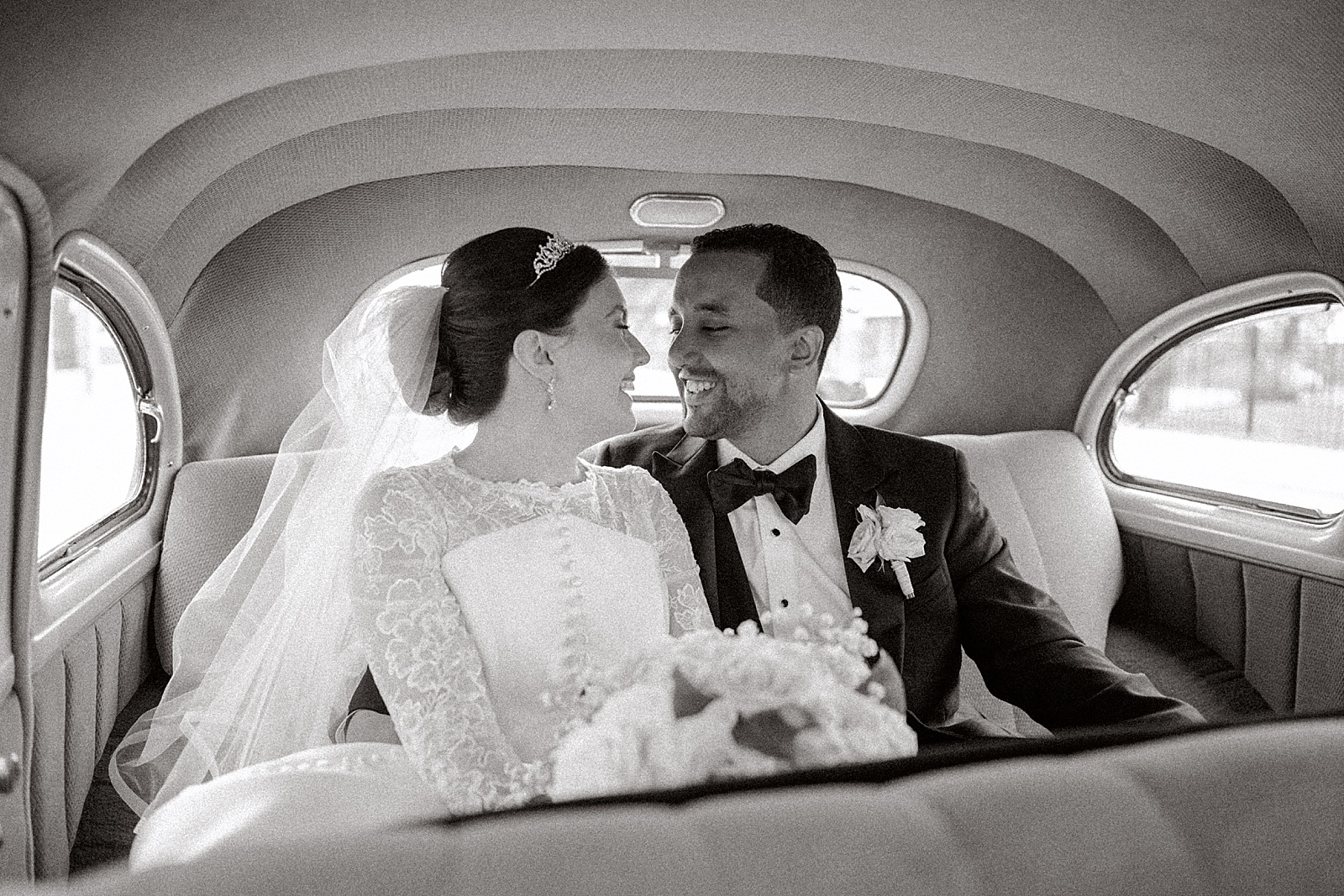 catholic bride and groom in their vintage detroit packard vintage car after their wedding mass at sweetest heart of mary in detroit michigan